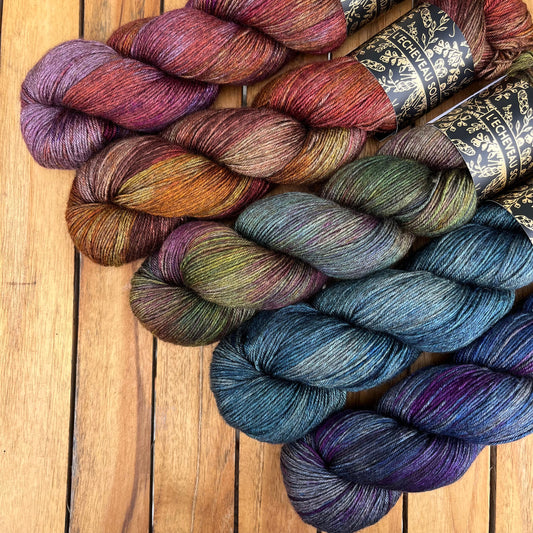 A skein of Equinox yarn weighing 100g in colorway Undyed which is globally the color grey