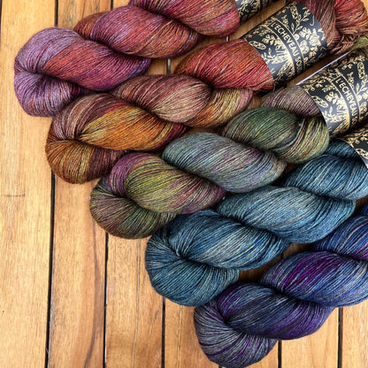 A skein of Equinox yarn weighing 100g in colorway Undyed which is globally the color grey